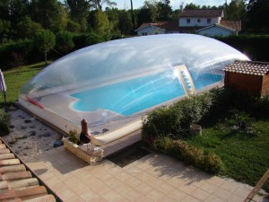 Photo de galerie -  Construction piscine 12 x 6 m, avec plage 90 m² en caillebotis (ici recouverte d'un abri gonflable)
