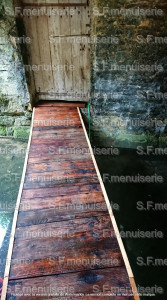 Photo de galerie - Une passerelle faite avec du bois de récupération afin d'avoir un passage stable 