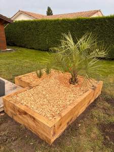 Photo de galerie - Réalisation d’une jardinière sur mesure en chêne français de Dordogne, avec apport de terre adaptée pour valoriser les plantations et structurer l’espace extérieur.