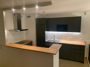 Photo de galerie - Voici un chantier de rénovation complète de cuisine : remplacement de tous les meubles, création d’un bar, installation de nouveaux spots, changement de la hotte et pose d’une faïence murale. Une remise à neuf totale, du sol au plafond.