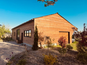 Photo de galerie - Pose de bardage, fabrication des menuiseries en bois, pose d’une porte de garages électrique recouverte de bardage