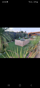 Photo de galerie - Création d' un massif de fleurs, pose de parment de pelouse synthétique et de pot et de plantation 