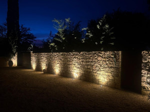Photo de galerie - Pose de sept spots dans le sol pour éclairer ce mur en pierre avec deux détecteurs qui allument le circuit automatiquement  