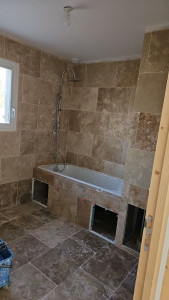 Photo de galerie - Salle de bain en travertin avec trape pour accéder a la plomberie en cas de fuites 
