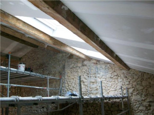 Photo de galerie - Réalisation d'un plafond suspendu sous toiture, avec plaque de plâtre, isolation thermique laine de verre de 300 mm (RE2020) , compris peinture plafond et poutres. Surface 160 m2, hauteur sous faîtage 9.50m