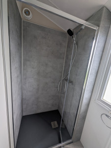 Photo de galerie - Rélisation d'une douche dans mobil home - Création de la structure porteuse, modification de la plomberie, pose du revêtement mural, du receveur et de la porte