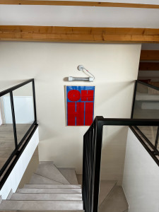 Photo de galerie - Accroche d’un néon et d’un cadre dans la cage d’escalier d’une villa. 