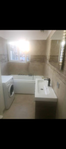 Photo de galerie - Restauration totale d'une salle de bain avec pose d'un SPA, carrelage sol et murs, meuble suspendu, miroir, ....