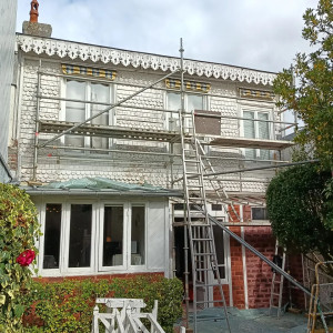 Photo de galerie - Remise en état de cette façade en bois ponçage  , reboucher tout les défauts  , nettoyage  , une couche  impression et 2 couches de peinture blanc 