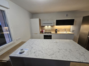 Photo de galerie - Pose d'une cuisine sûr mesures avec îlot en quartz.