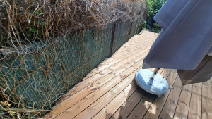 Photo de galerie - Création terrasse bois avec des coupes pour suivre le grillage et les murs de la maison et du contour du jardin non à angle droit tout en respectant un lambourdage d équerre 