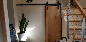 Photo de galerie - Fabrication d'une porte sur mesure en bois avec pose sur rail.
