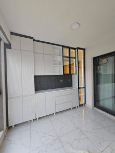 Photo de galerie - Fabrication et pose d’un dressing sur mesure avec portes vitrées, tiroirs intégrés et finitions soignées.