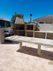 Photo de galerie - Puis une terrasse équipée d' un barbecue et une table faite en béton 