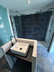 Photo de galerie - Création totale salle de bain avec bac a douche maçonné 3m x 0,9m double colonne de douche et meuble central sur mesure  