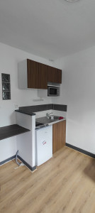 Photo de galerie - Aménagement et installation d'une kitchenette complète : pose des meubles hauts et bas, encastrement de l'évier, ajustement des plans de travail et intégration de l'électroménager.
