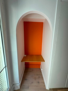 Photo de galerie - Création d’une niche sur mesure avec arche arrondie, tablette en bois, installation d’une double prise de courant et mise en peinture bicolore. Finitions très soignées pour un rendu propre et moderne.