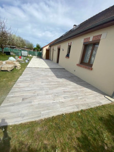 Photo de galerie - Réalisation d'une terrasse en carrelage imitation bois. Pose soignée avec alignement parfait, joints réguliers et finition durable, idéale pour les espaces extérieurs.