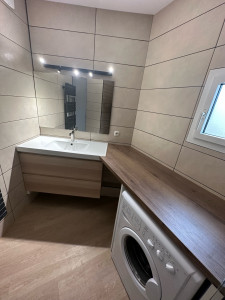 Photo de galerie - Belle salle de bain complète : bac à douche avec paroi/ faïence / meuble évier et parquet pvc au sol 