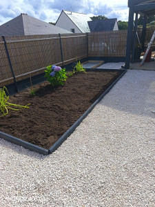 Photo de galerie - Création d'une allée en gravion avec nid d'abeille , pause de bordure, potager, dalle béton  pour barbecue , massif 