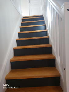Photo de galerie - Peinture escalier anciennement en chêne foncé partout réalisation des rambardes et main courantes en blanc contre marche en gris foncé couleur de la cuisine marches en naturel chêne incolore.