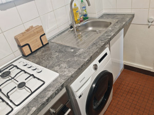 Photo de galerie - Installation de meubles de cuisine, d'un évier et d'un plan de travail.