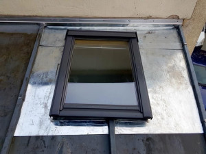 Photo de galerie - Pose d’une fenêtre de toit Velux avec réalisation d’un entourage sur mesure en zinc et raccordement à la couverture pour assurer une étanchéité optimale.