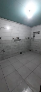 Photo de galerie - Posé de carrelage et faïences sur une salle de bain avec des niche inclus dans les murs .
