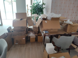 Photo de galerie - Déballer les objets et trier les cartons, papier et plastique pour dépôt déchetterie.