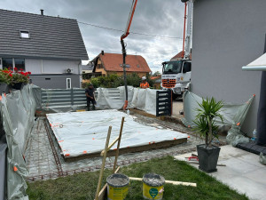 Photo de galerie - Création d'une dalle en béton autour d'une piscine avec terrassement manuel 