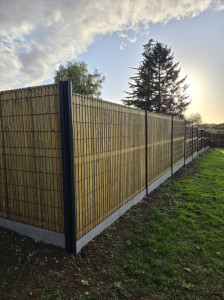 Photo de galerie - Pose de clôture rigide avec occultant bois 
Voici un exemple de réalisation : clôture rigide sur soubassement béton, avec panneaux occultants en bois pour plus d’intimité et d’esthétique.