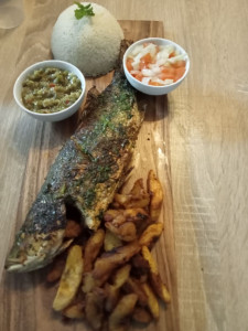 Photo de galerie - Poisson braisé accompagné de bananes plantain frire et semoule de manioc (attieke)