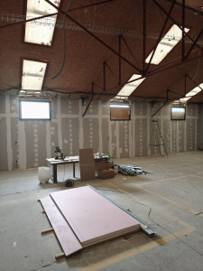 Photo de galerie - Pose d'isolant et habillage standard sur ossature métallique d'un mur de 15m de long sur 3m70 de haut avec pose de 3 fenêtres sur structure bois.