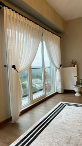 Photo de galerie - Pose de tringle sur grande baie vitrée : fixation solide sur mur porteur, alignement parfait et rendu élégant des rideaux.