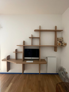 Photo de galerie - Bureau étagère en bois au design graphique et asymétrique, mêlant lignes épurées et rangements aériens. Une pièce à la fois pratique et sculpturale