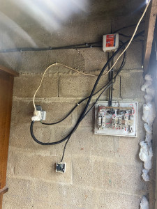 Photo de galerie - Avant intervention, ancien tableau électrique dans un garage ayant un risque d’électrocution 