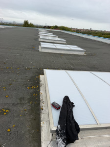Photo de galerie - Interventions d'étanchéité et remise en conformité des fixations de lanterneaux sur toiture industrielle / bâtiment.