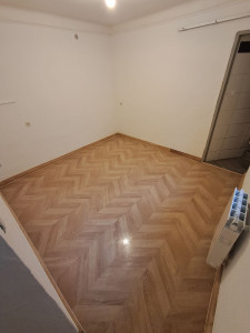 Photo de galerie - Pose parquet stratifié imitation chevron + plinthes assorties