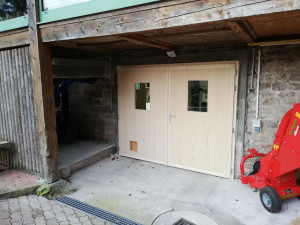 Photo de galerie - Porte de garage en sapin, interieur avec isolation naturel et  chatière ne laissant passer que son chat et pas ceux du voisin. Prise de mesure, fabrication, livraison et pose. 