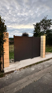 Photo de galerie - Pose finale du portail battant avec installation des deux piliers et réalisation des finitions de la dalle en béton.