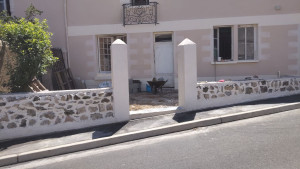 Photo de galerie - Exécution de fondation en redant,  pose de parpaing avec parement en pierre de granit et rejointoiement pose d'enduit finition talochée.
