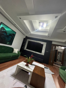 Photo de galerie - Rénovation haut de gamme du salon : peinture et décoration impeccables, pose de TV murale et reprise de la teinte du parquet pour un espace élégant, moderne et harmonieux