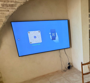 Photo de galerie - Installation télévision sur un mur avec système d’accroche dédié. Paramètrage de l’installation et la Freebox TV.
