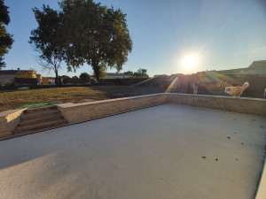 Photo de galerie - Réalisation d'un muret en pierre naturelle avec marche en traverses de chemin de fer . drainage derrière le mur pour le terrain et terrasse béton 60m2 avec caniveaux vers les eaux pluviales. 