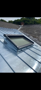 Photo de galerie - Réalisation d’une toiture en zinc à joint debout . Avec création d’un entourage sur-mesure. pour fenêtre de toit VELUX. finition, soigner et raccord d’étanchéité précis. garantissant une étanchéité et une protection durable contre les intempéries.