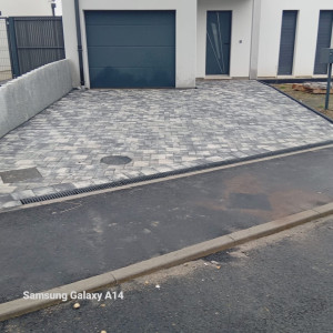 Photo de galerie - Le travail réalisé correspond à une pose de pavés pour une allée/parking devant la maison. Les pavés sont bien alignés, avec une finition propre et régulière, ce qui montre un bon niveau de précision de notre travail 
