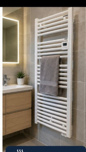 Photo de galerie - Pose et raccordement d’un sèche-serviettes dans une salle de bain. Installation soignée et mise en service du système de chauffage.


