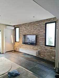 Photo de galerie - Réalisation d'un mur 13 m² en parement de pierres naturelles plus pose de TV 165 cm et meuble suspendu. Merci a Mahrez pour sa confiance.