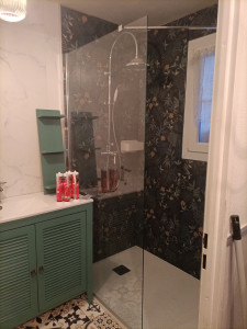 Photo de galerie - Réflexion d'une salle de bain pose de carrelage bac à douche peinture du meuble évier ainsi que des étagères pose du sol en lino pose de dalle PVC contre le mur réfection de salle de bain au neuf