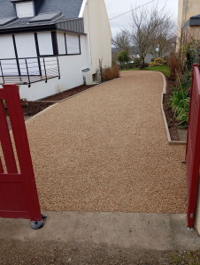 Photo de galerie - Réalisation d'une allée en gravillons sur alvéoles avec géotextile et pose de pavés et bordures hautes 